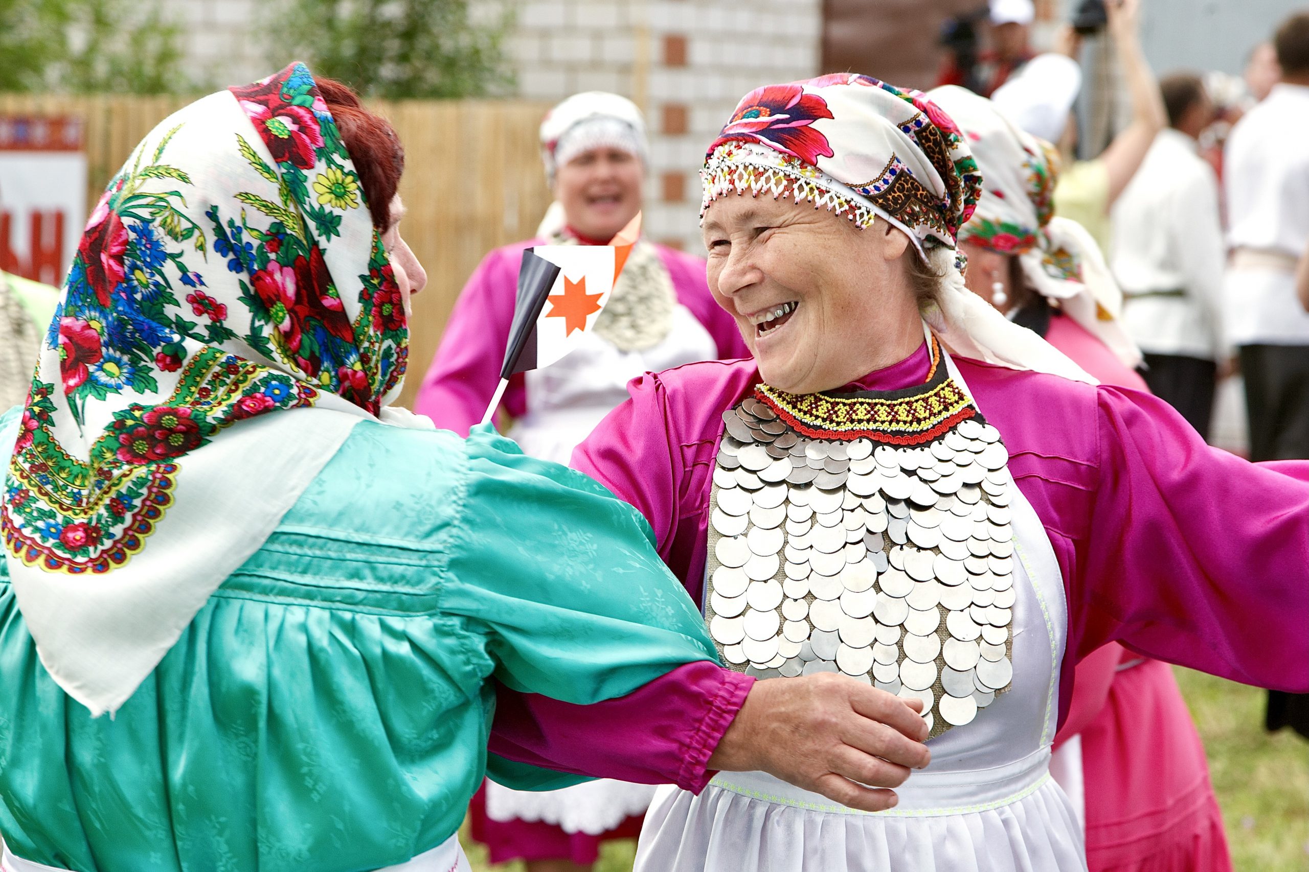 Фото двух женщин в национальных костюмах, танцующих на празднике окончания весенних полевых работ